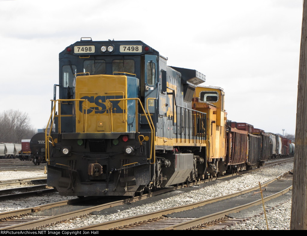 CSX 7498 waits with a caboose and three gons before starting tie pickup duty